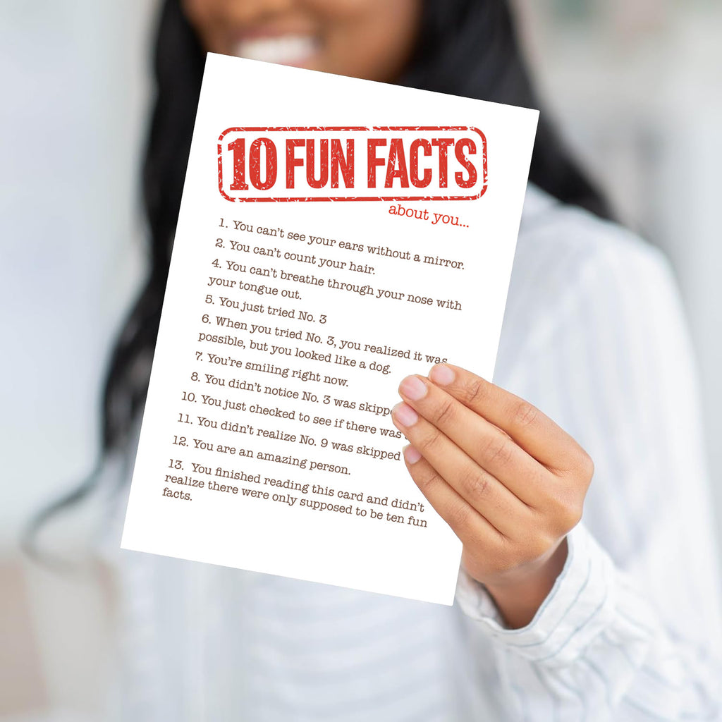 A person holding the Fun Facts card to demonstrate the scale and the heavy, professional feel of the paper.