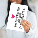 A person holding the "Pain in the Ass" card to demonstrate the professional weight and large scale of the product.