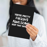 A person holding the bold "F*cking Awesome" card to demonstrate the professional weight and large scale of the product.
