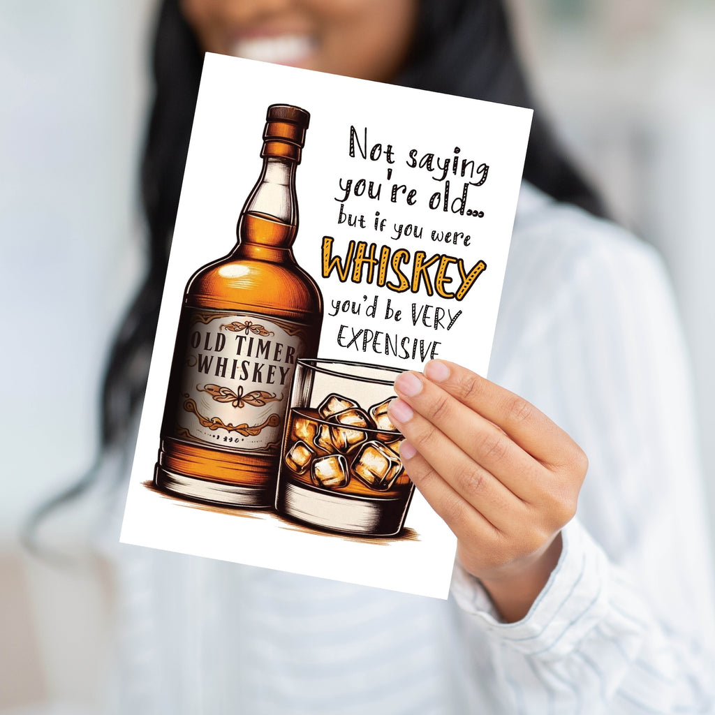 Close-up of vintage-style whiskey bottle and glass artwork on birthday card.