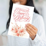 A person holding the floral birthday card to demonstrate the substantial weight and professional feel of the paper.